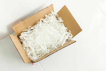Fototapeta na wymiar White shredded paper in cardboard box.