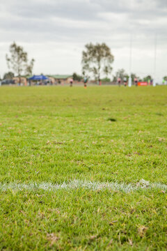 White line on a playing field with out of focus sport players in the background