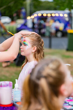 Girl at local event getting face painted with floral design