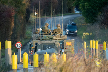 convoy of vehciles and soldiers on a road