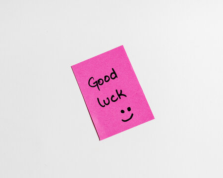 Yellow sticky note with text "good luck". with happy smiley face