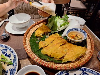 Traditional Vietnamese dish, "Banh Xeo," eaten with rice paper