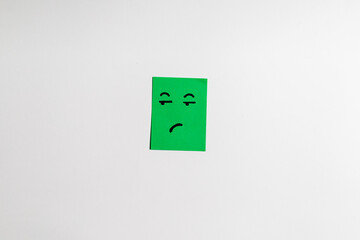 angry face on green short note paper white background