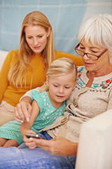 Girl, phone and social media at a home with grandmother, family and mother together with game. Learning, online and senior woman with child and mom with love, support and care in a house with tech