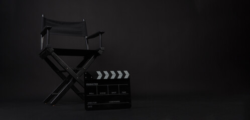 Director chair and black lapper board on black background.