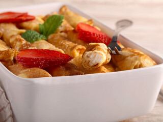 Baked mini crepes rolls filled with cheese