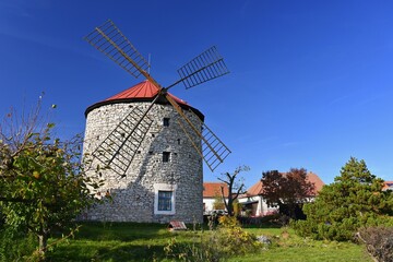 Obraz premium Beautiful old windmill and landscape with the sun. Ostrov u Macochy, Czech Republic. Europe.