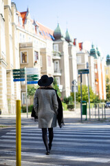 A girl in a hat walks along a pedestrian crossing