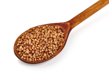 Buckwheat grains on a wooden spoon, isolated on white background.