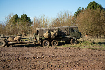 British army bae systems, Puch, Daimler, Pinzgauer High-Mobility All-Terrain 6x6 vehicle towing a 105mm Light Artillery Gun on a military exercise © Martin