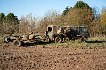 British army bae systems, Puch, Daimler, Pinzgauer High-Mobility All-Terrain 6x6 vehicle towing a 105mm Light Artillery Gun on a military exercise © Martin