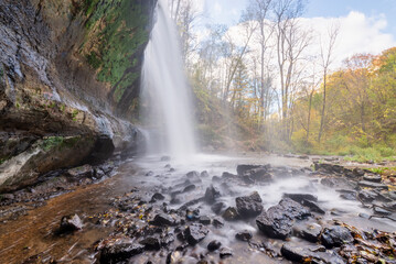 Fototapeta na wymiar waterfall in autumn, view from behind falls 