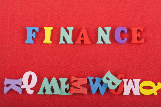 FINANCE word on red background composed from colorful abc alphabet block wooden letters, copy space for ad text. Learning english concept.