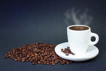 A pile of coffee beans, a white cup of coffee on a dark background. Front view.