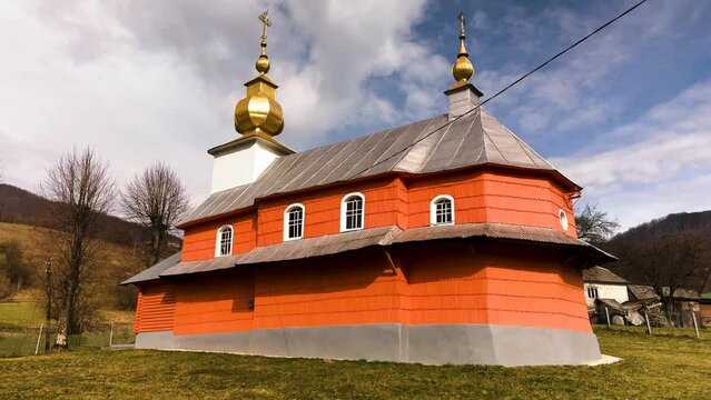 Ukraine, Carpathians, mountain village with a beautiful restored classical Christian church, colorfully painted orange. Yalove village, Mukachevo district.

