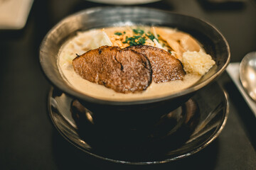 Savory Gourmet Pork Ramen Noodle Cutlet in Cream Sauce Served in a Stylish Bowl
