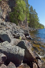 Rocky lake shore at Päijänne National Park in sunny summer weather, Finland.