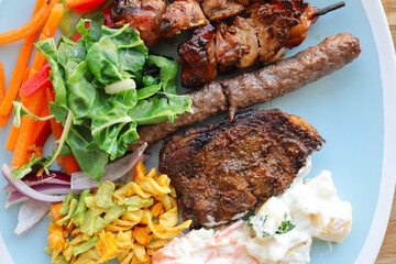 Plate of South African braai meat. Boerewors, chicken kebabs and lamb chops