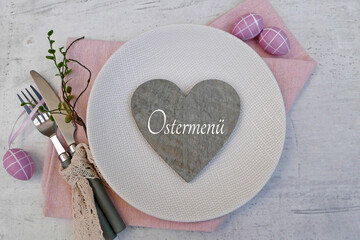 Ostermenü: Besteck mit Teller und Oster Dekoration auf einem Tisch .	