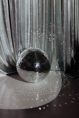 A disco ball rests on the floor. The atmosphere of a dance or party setting. Concept for event...