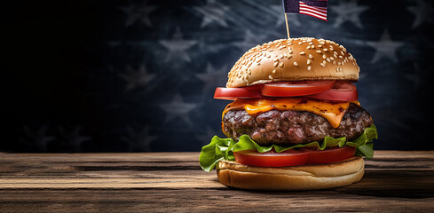 a close-up of a beef burger with the American flag stuck on top, on a wooden table, on a dark blue background. A festive snack for a picnic on the Fourth of July Independence Day.