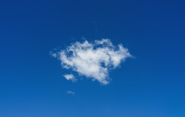 Fototapeta na wymiar Single white cloud on blue sky background
