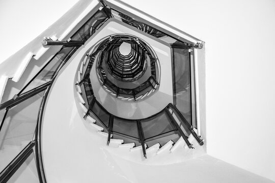 Vista desde abajo de una escalera de caracol, en blanco y negro