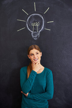 Thinking, creative and woman with light bulb on chalkboard for inspiration, brainstorming and problem solving. Idea, question and person on background with icon for solution, thoughtful and planning
