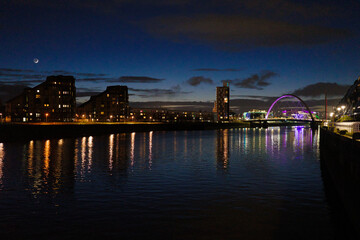 Fototapeta na wymiar Glasgow Scotland: 11th Feb 2024: The Clyde Arc illuminated at night on the Banks of the River Clyde aka the Squinty Bridge