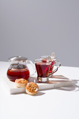 Té rojo con pasteles y dulces sobre mármol	