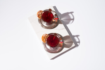 Dos tazas de té rojo con pasteles y dulces sobre mármol	