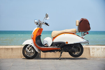 An old vintage scooter on the beach by the sea. Transport for city trips