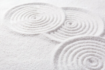 Fototapeta na wymiar Zen rock garden. Circle patterns on white sand, closeup