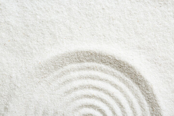 Fototapeta na wymiar Zen rock garden. Circle pattern on white sand, top view. Space for text