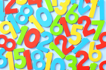 Colorful numbers on light blue background, flat lay