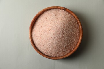 Himalayan salt in bowl on grey background, top view