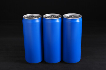 Energy drinks in blue cans on black wooden table