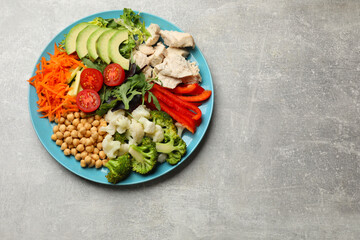 Balanced diet and healthy foods. Plate with different delicious products on grey table, top view. Space for text