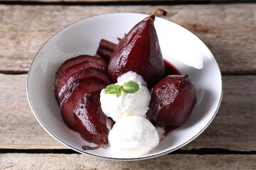 Tasty red wine poached pears and ice cream in bowl on wooden table, closeup