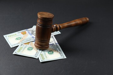 Law gavel with dollars on grey table