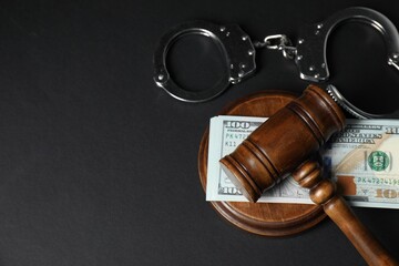 Law gavel, dollars and handcuffs on grey table, flat lay. Space for text