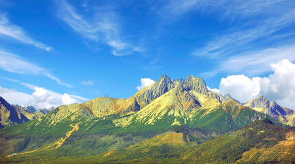 Panoramic view of Tatra mountains under blue sky with clouds, Slovakia.