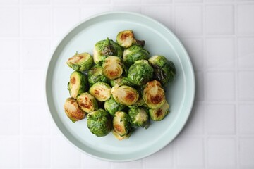 Delicious roasted Brussels sprouts on white tiled table, top view