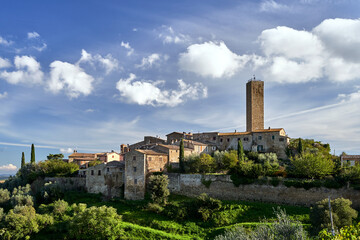 Fototapeta na wymiar stone houses, bell tower and medieval tower on top of a hill in the town of Pereta in Tuscany