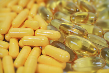 Tablets, yellow capsules on natural background with selective focus. Pills for heart and vascular...