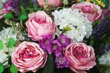 A bouquet of pink and white flowers with purple flowers in the middle