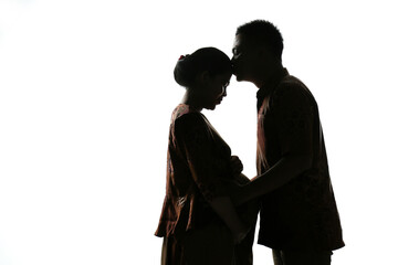 The silhouette of the husband kissing his pregnant wife's forehead on a white background