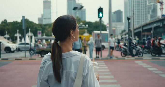 Lively modern metropolis woman crosses pedestrian crossing surrounded by crowd people. Pedestrian crossing safe passage in urban traffic Pedestrian crossing blending with cities rhythm.