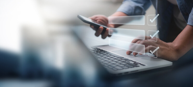 Digital smart checklist and business management concept. Businessman uses laptop to mark paperless office and document management and future business on checklist