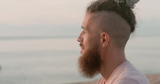 Beach at sunset man in deep thoughtfulness side view close-up Thoughtfulness component of summer relaxation. Thoughtfulness blending with nature's quiet Pathway to life contemplation.